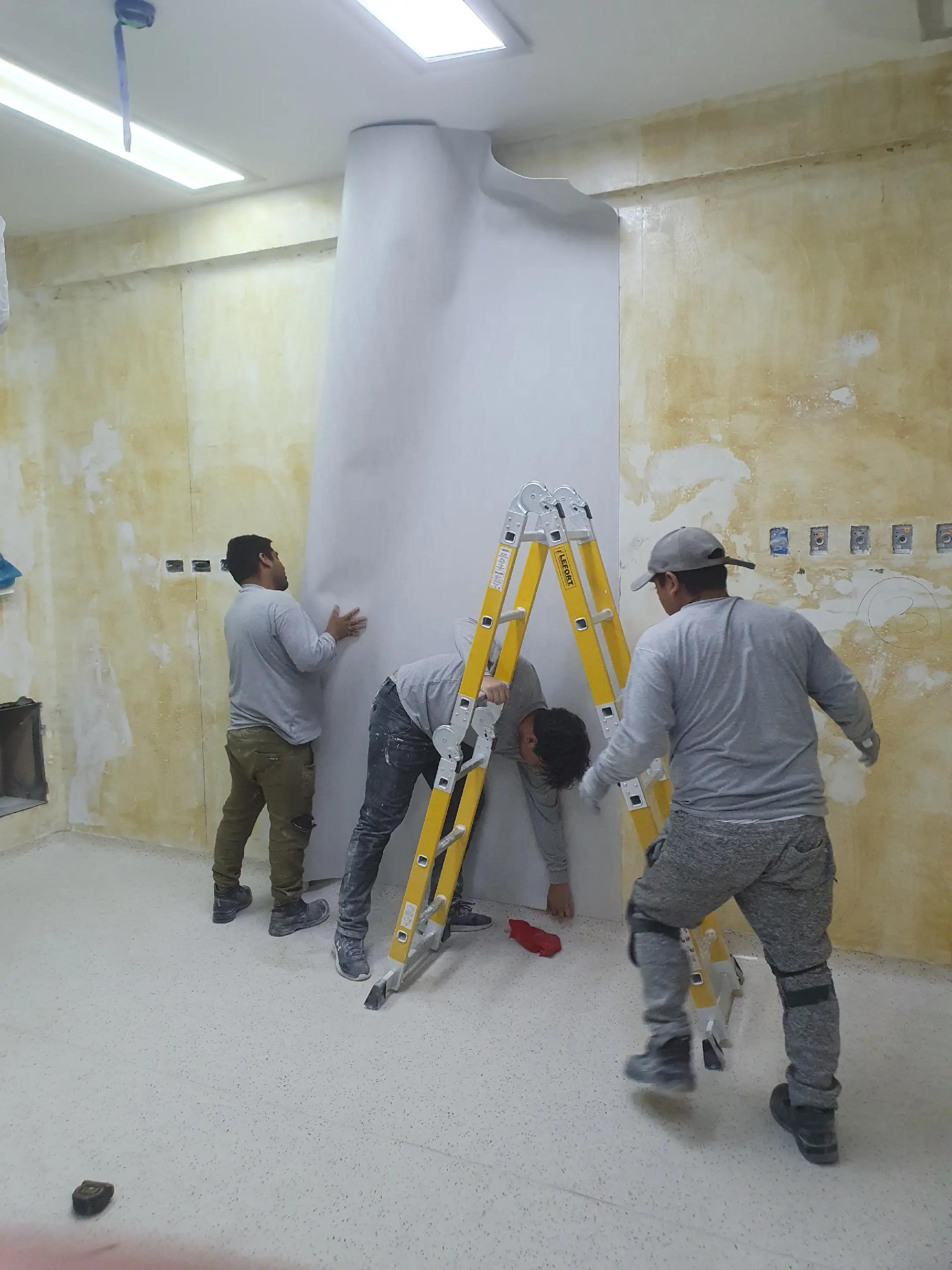 Equipo de ADN Construcción instalando un panel curvo de pared en la sala DaVinci del Hospital Dos de Mayo, Lima